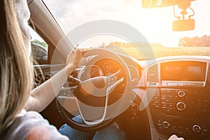 Car driving. Fun driver ride vehicle on road in travel trip. Happy young woman inside car on sunset in summer vacation