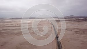 Car driving on gravel road in aerial desert. Sandy landscape, nobody in Namibia.