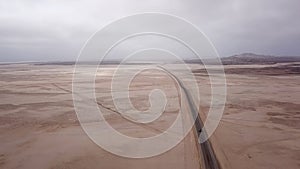 Car driving on gravel road in aerial desert. Sandy landscape, nobody in Namibia.