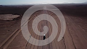 Car driving on gravel road in aerial desert. Sandy landscape, nobody in Namibia.