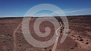 Car driving on gravel road in aerial desert. Sandy landscape, nobody in Namibia.