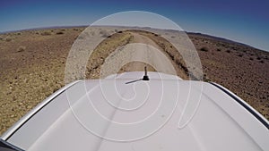 Car driving on gravel road in desert. Sandy landscape, nobody in Namibia.