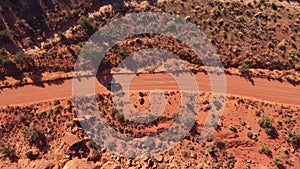 Car Driving On Ground Road Crossing Red Sand Desert On Sunny Day Aerial View