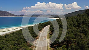 The car driving the highway along the Salda lake. Aerial view