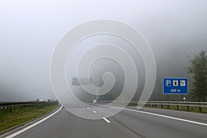 Car driving on  highway in heavy fog.  Traffic safety  in heavy fog.