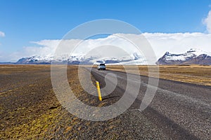 Car driving on the Icelandic ring road passes the Vatna Glacier