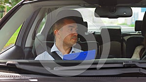 Car driving instructor talking to upset woman