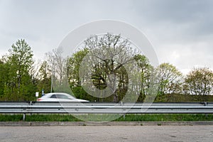 Car driving by in motion blur on highway. A view from highway resting area