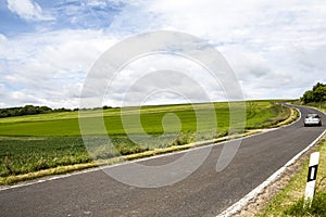 A car is driving on the national road in the countryside of Germany