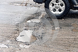 Car driving through a pothole with splashes of water