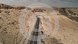 car driving on road through the desert, the camera flies over the land, the landscape in Israel