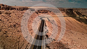 car driving on road through the desert, the camera flies over the land, the landscape in Israel