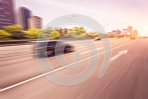 Car driving on road at sunset, motion blur