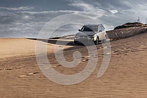 Car driving through sand dune