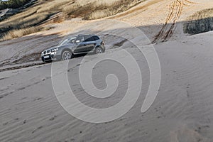 Car driving through sand dune