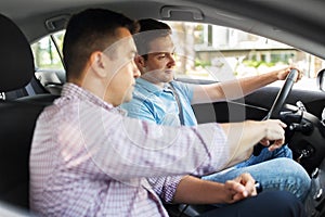 Car driving school instructor teaching male driver