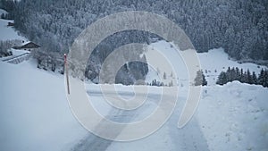 Car driving on a snowy mountain road. View through the windshield