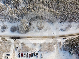 Car driving on winter country road in snowy forest