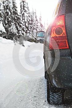 Car driving on a winter road in the snow. Close up  shallow depth of field