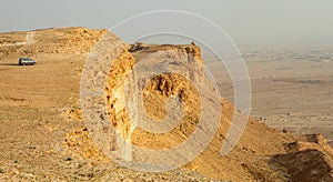 Car on the edge of the Jabal Tuwaiq Mountains, with desert landscape, Riyadh, Saudi Arabia