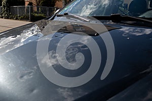 Car engine hood with many hail damage dents show the forces of nature and the importance of car insurance and a replacement value