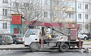A car equipped with a lifting device is parked on a city street