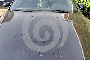 Car in Europe covered in Sahara sand transported by southerly winds, words written in dust photo