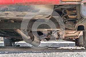 Car exhaust, muffler fallen down - view of chassis of a car