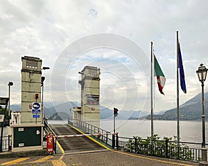 Car Ferry dock in Varenna on Lake Como with a gothic lamp and flags. photo