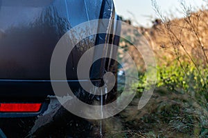 Car in the field in summer sunrise