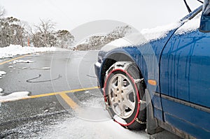 Car with fitted tire chains or snow chains on its front wheels