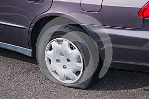 Car with a flat tire on an asphalt parking lot