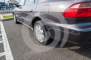 Car with a flat tire on an asphalt parking lot