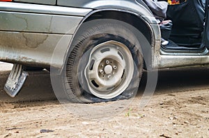 Car flat tire on a bad road