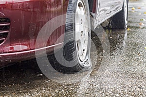 Car flat tire in rainy day