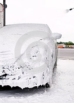 car in foam and detergent bubbles at the sink