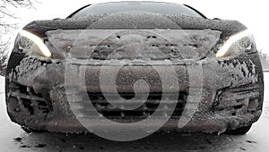 Car front covered with frozen snow