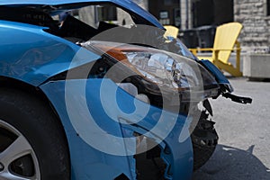 Car front hood and headlight damaged after accident. Shot from the side.