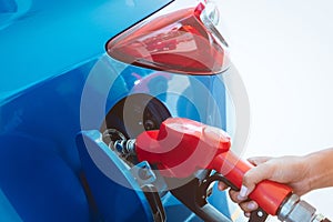 Car fueling at gas station. Refuel fill up with petrol gasoline. Petrol pump filling fuel nozzle in fuel tank of car at gas