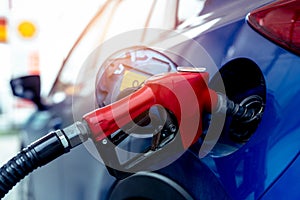 Car fueling at gas station. Refuel fill up with petrol gasoline. Petrol pump filling fuel nozzle in fuel tank of car at gas