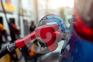 Car fueling at gas station. Refuel fill up with petrol gasoline. Petrol pump filling fuel nozzle in fuel tank of car at gas