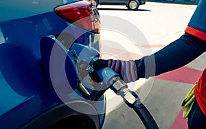 Car fueling at gas station. Refuel fill up with petrol gasoline. Petrol pump filling fuel nozzle in fuel tank of car at gas