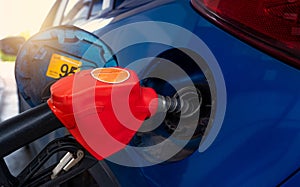 Car fueling at gas station. Refuel fill up with petrol gasoline. Petrol pump filling fuel nozzle in fuel tank of car at gas