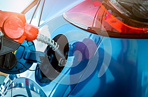 Car fueling at gas station. Refuel fill up with petrol gasoline. Petrol pump filling fuel nozzle in fuel tank of car at gas