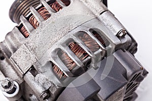 Car generator, car electrical network element on white background, generator details close-up. Spare auto parts for repair