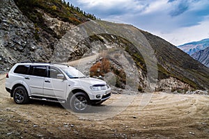 A car going down a mountain road from the Katu-Yaryk pass to the valley of the Chulyshman river