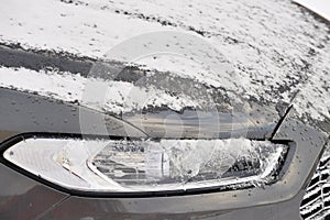 Car headlamp covered by snow and ice