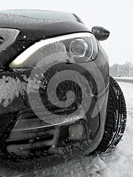 Car headlight covered with frozen snow