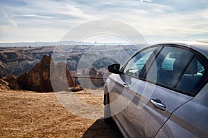 Car on high observation deck for looking on strange landscape in Cappadocia valley with yellow mountains, rocks and hills and blue