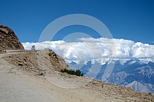 A car on Himalayas Khardung La pass high altitude road.